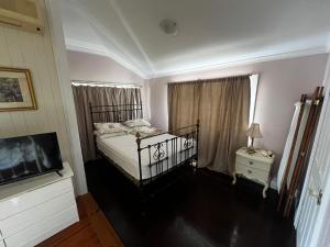 a bedroom with a bed and a flat screen tv at Homestead BnB in Maudsland