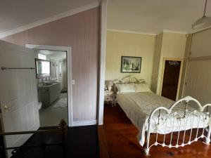 a bedroom with a bed and a bathroom with a sink at Homestead BnB in Maudsland