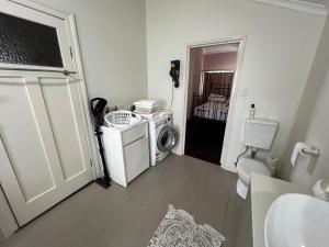 a small bathroom with a washing machine and a washer at Homestead BnB in Maudsland +16 photos