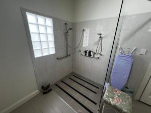 a bathroom with a walk in shower with a window at Homestead BnB in Maudsland