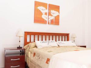 a bedroom with a bed with two night stands and two lamps at Depto 1 in Villa Carlos Paz