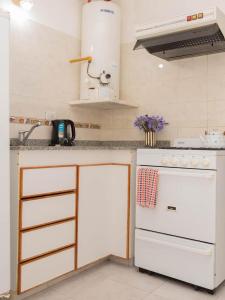 a kitchen with a white stove and a sink at Depto 1 in Villa Carlos Paz