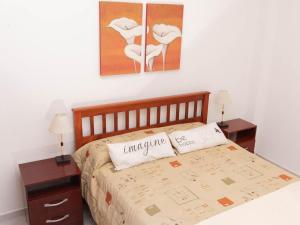 a bedroom with a bed with two tables and two paintings at Depto 1 in Villa Carlos Paz +4 photos