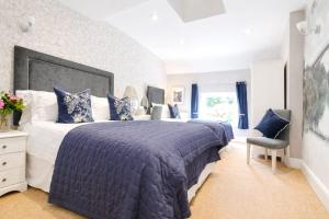 a bedroom with a large bed with blue pillows at Ironbridge View Townhouse - WINNER 2026 UK MOST PICTURESQUE SELF-CATERING HOLIDAY HOME & 2026 SELF-CATERING ACCOMMODATION OF THE YEAR in Ironbridge