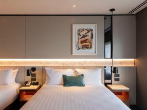 a bedroom with a large white bed with two pillows at Crowne Plaza Auckland by IHG in Auckland