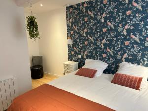 a bedroom with a bed with a floral wallpaper at Gite MIRABELLE in Saint-Rémy-Boscrocourt