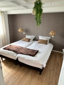 a bedroom with a large bed with white sheets at Gite MIRABELLE in Saint-Rémy-Boscrocourt
