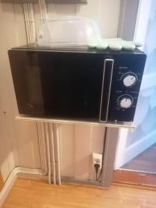 a microwave sitting on a shelf in a room at The top half of a house with sea view in Steinkjer