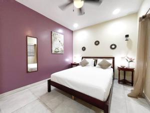 a bedroom with a white bed and purple walls at BethsAida Conference Center & Boutique Accommodations in Simpson Bay +29 photos