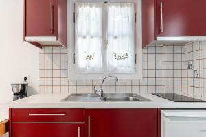 a kitchen with red cabinets and a sink at Crystal Naxos 1 Studios at Mikri Vigla in Mikri Vigla +90 photos