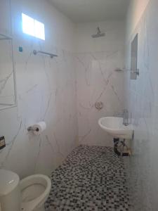 a white bathroom with a toilet and a sink at Casa alexander 2 in Acapulco