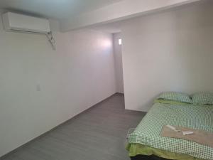 a bedroom with a bed and a white wall at Casa alexander 2 in Acapulco