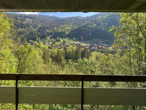 a view of a town in the mountains from a window at Superbe terrasse proximité centre in Morzine