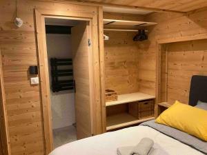 a bedroom with a bed in a wooden cabin at Superbe terrasse proximité centre in Morzine