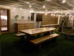 a kitchen with a wooden table and a bench at Superbe terrasse proximité centre in Morzine +19 photos