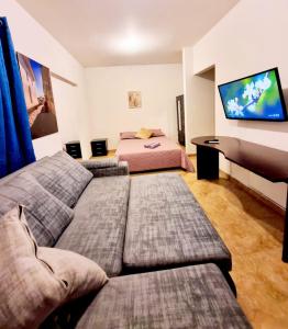 a living room with two beds and a flat screen tv at Colonial Travel Popayán in Popayan