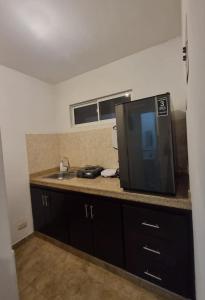 a kitchen with a microwave and a television on a counter at Colonial Travel Popayán in Popayan