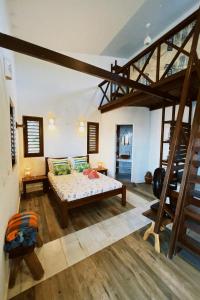 a large room with a bed and a staircase at Casa do Prãna in Guajiru