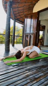 a woman laying on a yoga mat on a deck at Casa do Prãna in Guajiru