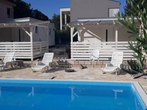 a group of chairs sitting next to a swimming pool at BUNGALOW VICE with pool in Pakoštane