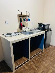 a kitchen with a sink and a stove at Departamento Flores in Catemaco