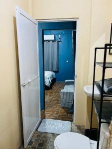 a bathroom with a door open to a room with a bed at Departamento Flores in Catemaco