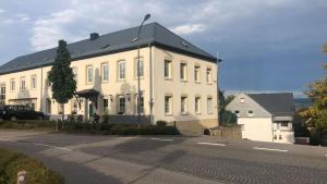 een groot wit gebouw met een zwart dak bij Pellinger-Hof in Pellingen