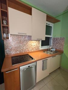 una cucina con mobili bianchi e un forno a piano cottura di Glyfada Menigos Apartment 21 a Glifada (Glyfada)