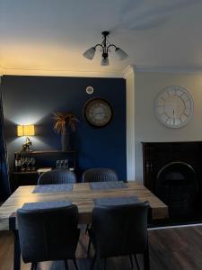 a dining room with a table and chairs and a clock at StoneHaven Townhouse in Donegal