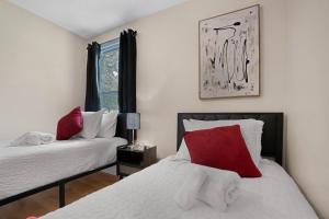 a bedroom with two beds with red and white pillows at Carbon Ridge 300mbps WiFi - Dog Friendly in Oak Grove