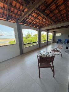 a room with two chairs and a table and windows at Recantodomarsaojose in São José de Ribamar