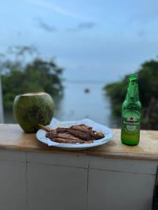 a plate of steak next to a bottle of beer at Recantodomarsaojose in São José de Ribamar