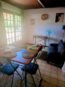 a living room with a table and chairs and a couch at Le temps d'une pause in La Foa