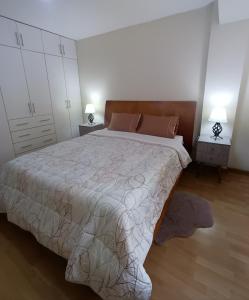 een slaapkamer met een groot bed en twee nachtkastjes bij Miraflores View in Lima