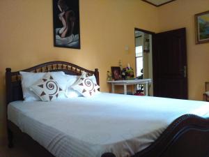 una camera da letto con un grande letto con lenzuola e cuscini bianchi di Illumination Stay a Negombo