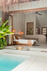 ein Schlafzimmer mit Bett und ein Swimmingpool in der Unterkunft Suenos Villas Siargao in General Luna