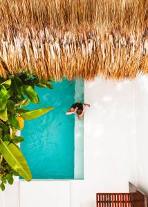 ein Vogel schwimmt im Wasser unter einem Strohdach in der Unterkunft Suenos Villas Siargao in General Luna