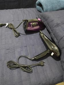 a hair dryer sitting on top of a bed at CAMINHOS do MAR ACOMODAÇÕES in Parnamirim