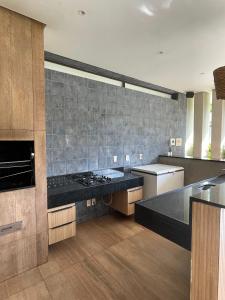 a large kitchen with a black counter top at CAMINHOS do MAR ACOMODAÇÕES in Parnamirim