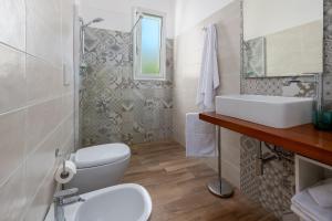 a bathroom with a toilet and a sink and a mirror at Villa Leomaris in Torre dell'Orso +37 photos