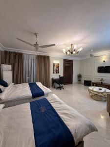 een grote slaapkamer met een bed en een woonkamer bij Qayaam Lodges in Islamabad