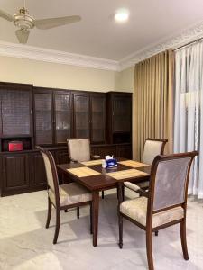 een eetkamer met een houten tafel en stoelen bij Qayaam Lodges in Islamabad