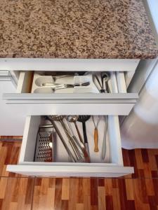 een keukenkastje vol keukengerei onder een aanrecht bij wind house - casa del viento in Perito Moreno