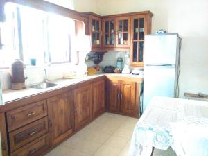 a kitchen with wooden cabinets and a white refrigerator at Illumination Stay in Negombo