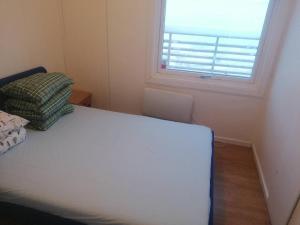 a small bedroom with a bed and a window at The top half of a house with sea view in Steinkjer
