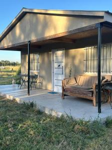 a covered patio with a bed and a table at Chacra Epona 2 in General Las Heras