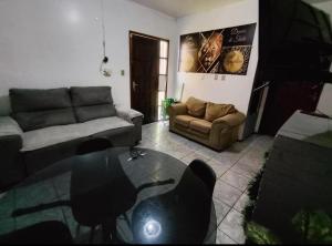 a living room with a couch and a glass table at POUSADA TEMPORADA BIBi casa inteira com café in São Gabriel +2 photos