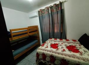 a bedroom with a bed with a flowered comforter at POUSADA TEMPORADA BIBi casa inteira com café in São Gabriel