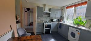 a kitchen with a stove and a washing machine at Eighteen in Jesmond