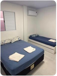 a room with two beds with towels on them at Pousada da Praça in Rosário do Sul